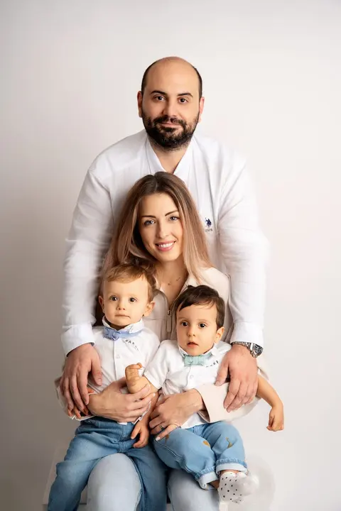 Семеен портрет: мама седи с двете момченца в скута, татко ги прегръща отзад